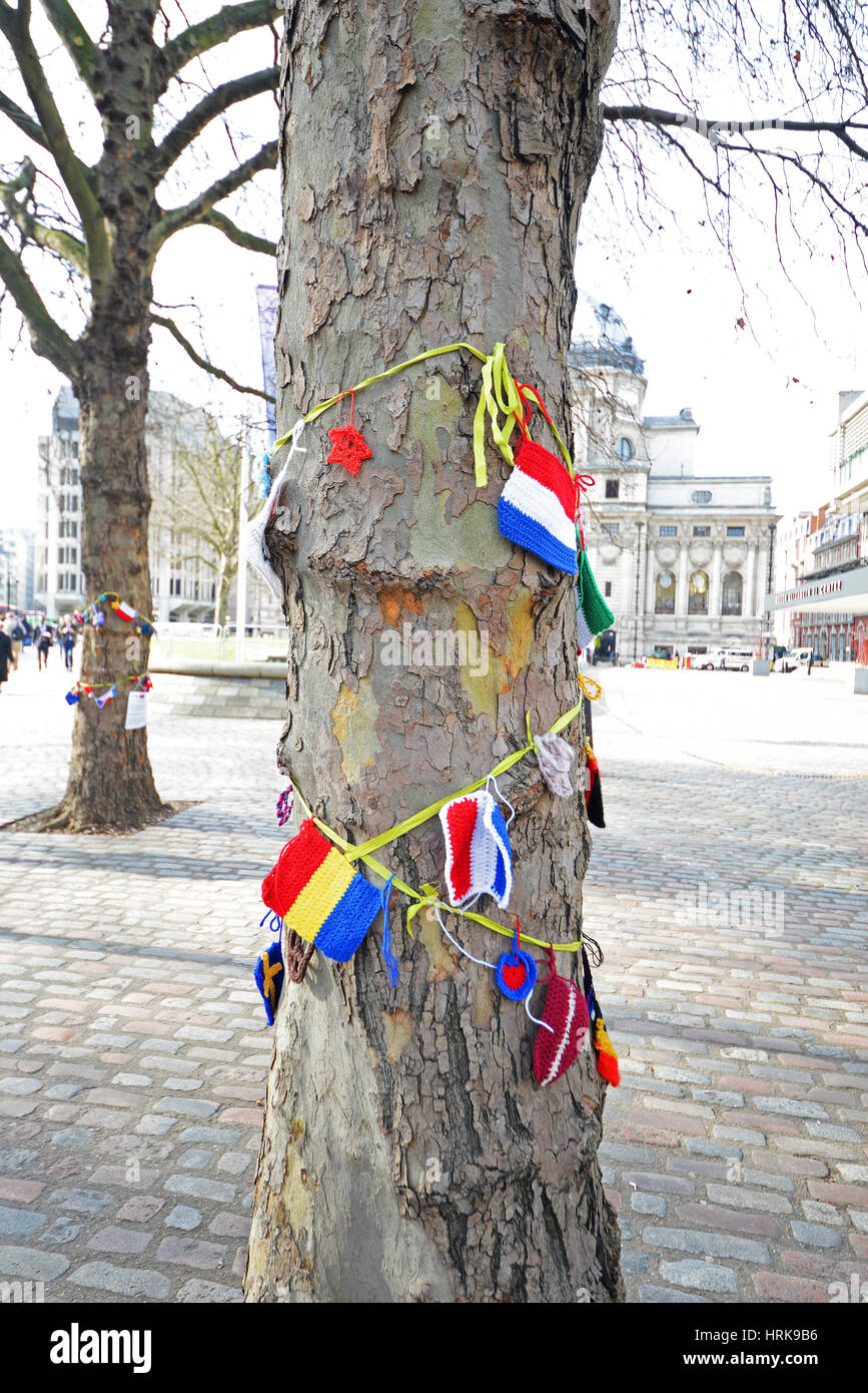 Trees adorned with knitted national flags and colours as part of 'One day without us' supporting European nationals in the UK Stock Photo