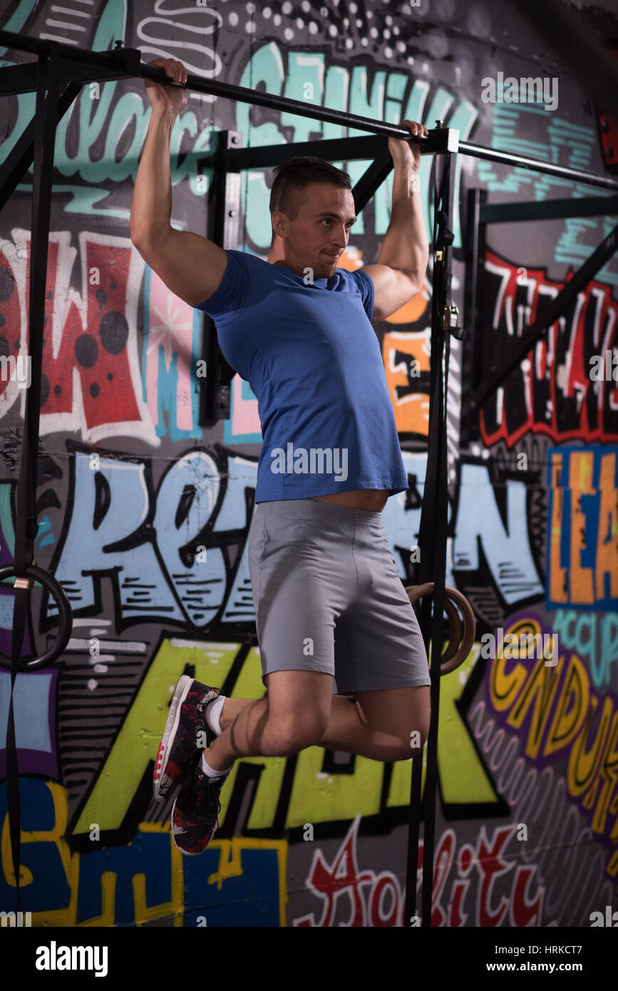 strong young man doing pull ups on a bar in a gym Stock Photo - Alamy