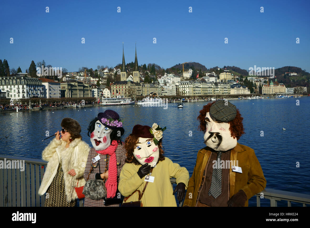 Carnival dressed people on Seebrücke with Lake Lucerne and Hof Quai, Luzern, Switzerland Stock Photo