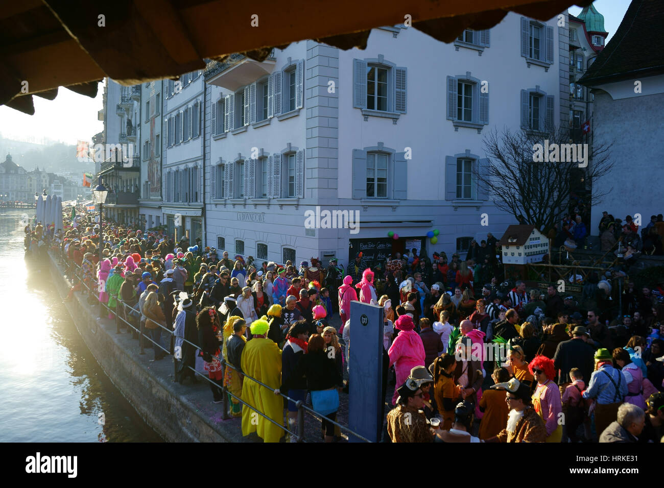 Carneval in Lucerne, people along Reuss river seen from Chapel bridge, Luzern, Switzerland Stock Photo