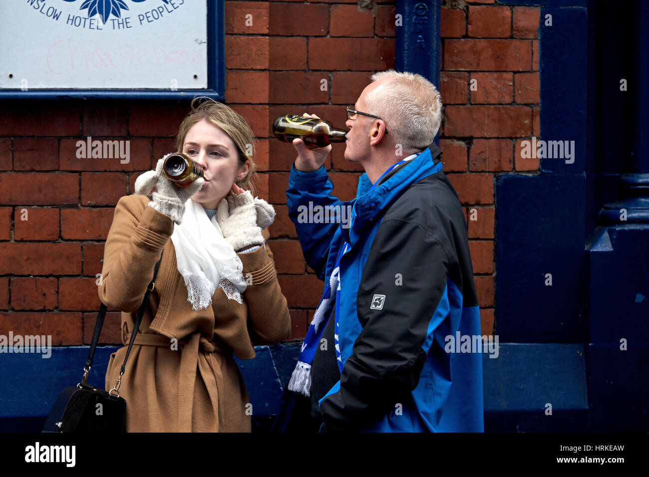 A man and woman having a drink outside a pub before going into an Everton home game at Goodison Park, Liverpool, UK Stock Photo
