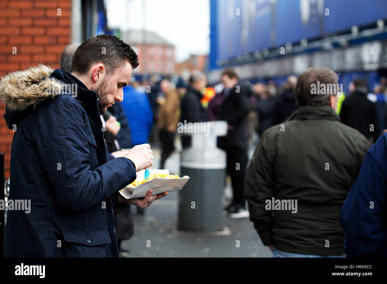 A man eating chips before going into Goodison Park for an Everton home match Stock Photo
