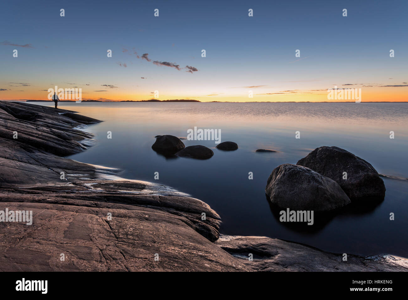 Man watching sunset by calm sea in Archipelago Sea National Park in South West Finland Stock Photo