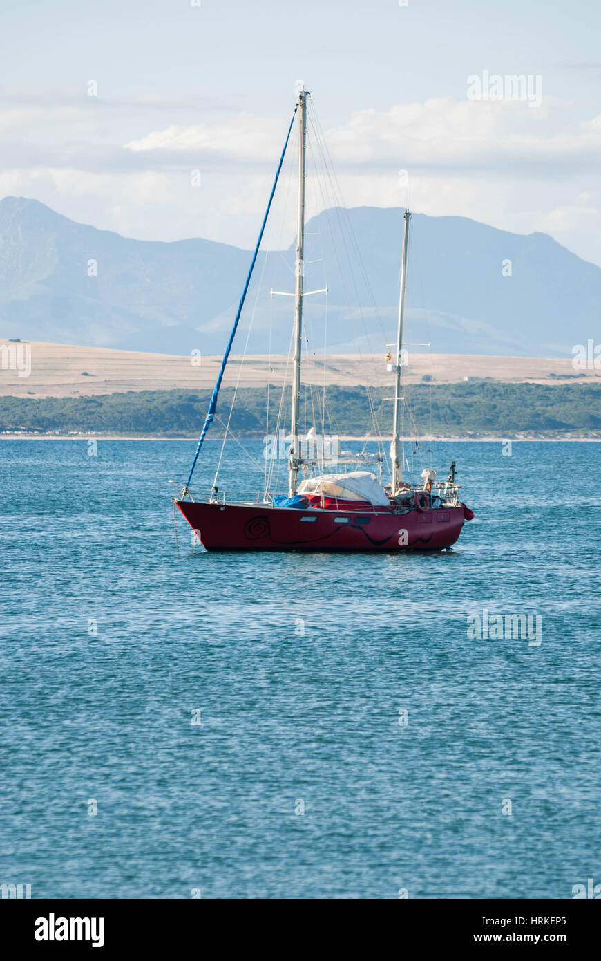 A red yacht on a calm ocean in Mossel Bay, South Africa Stock Photo