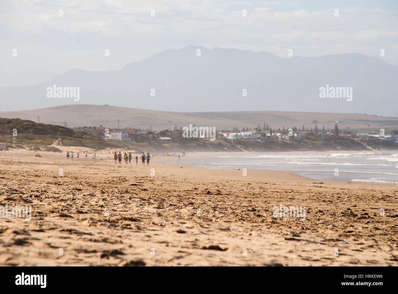 People walking along a beach in Mossel Bay, South Africa Stock Photo