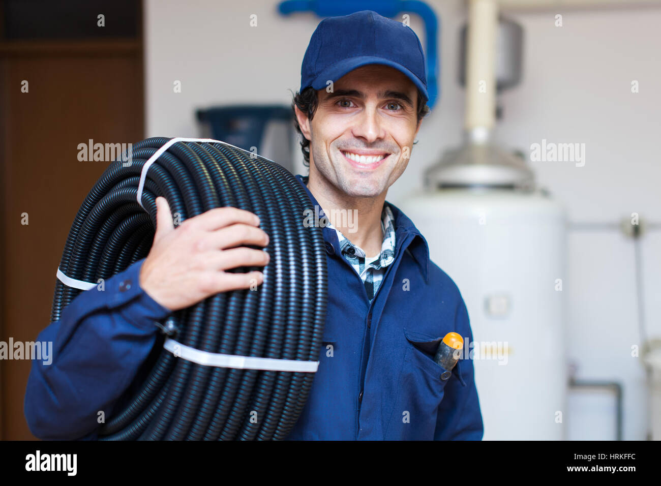 Portrait of a smiling worker carrying corrugated conduit Stock Photo