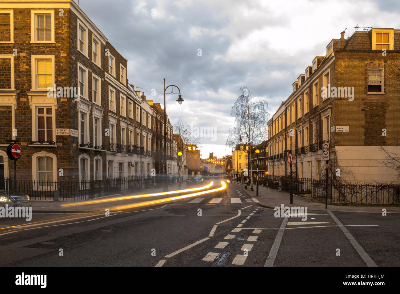 Block of flats at sunset and the light of the cars marking lines during ...