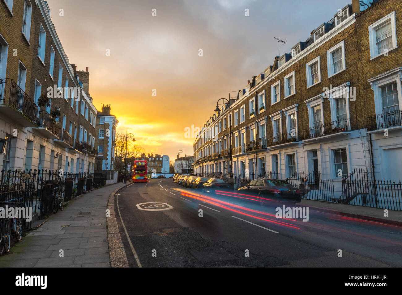 Block of flats at sunset and the light of the cars marking lines during ...