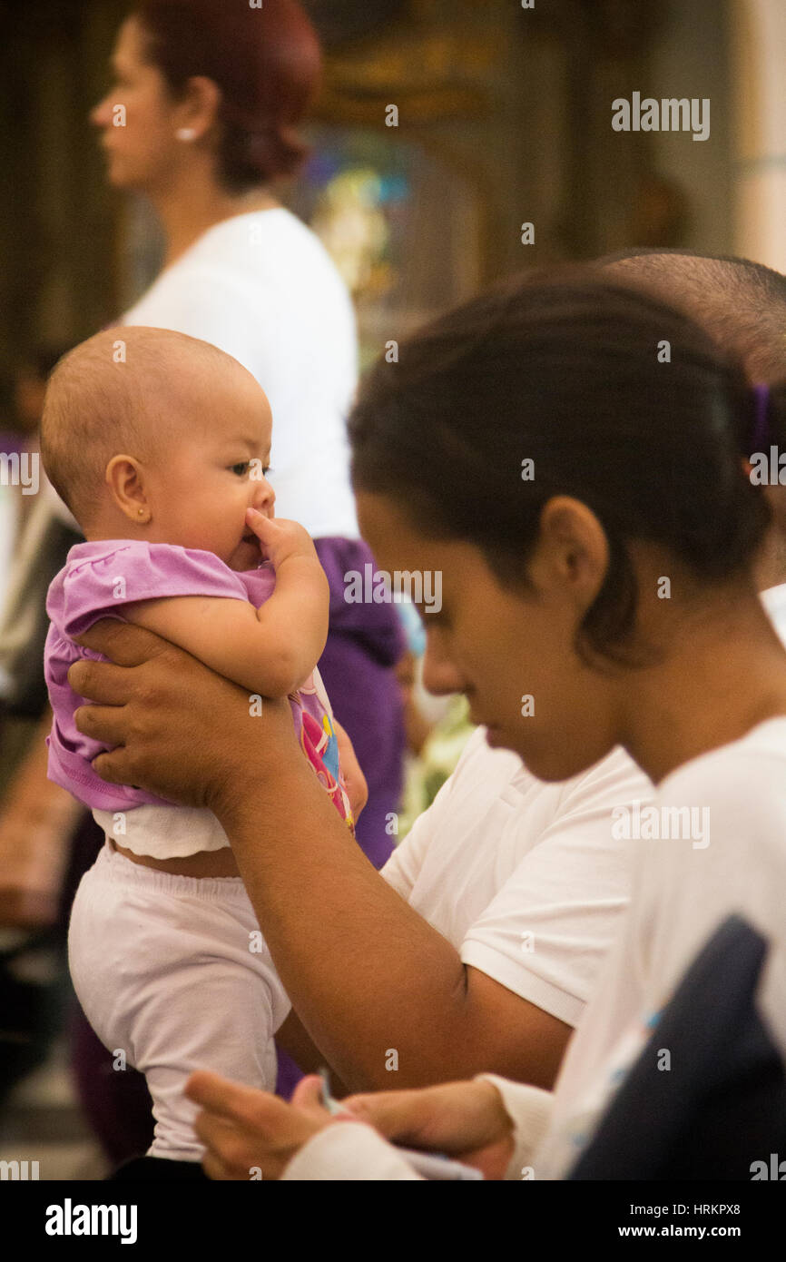 Venezuela Caracas 26/03/2013. Mother with her baby in church during Easter celebrations. Stock Photo