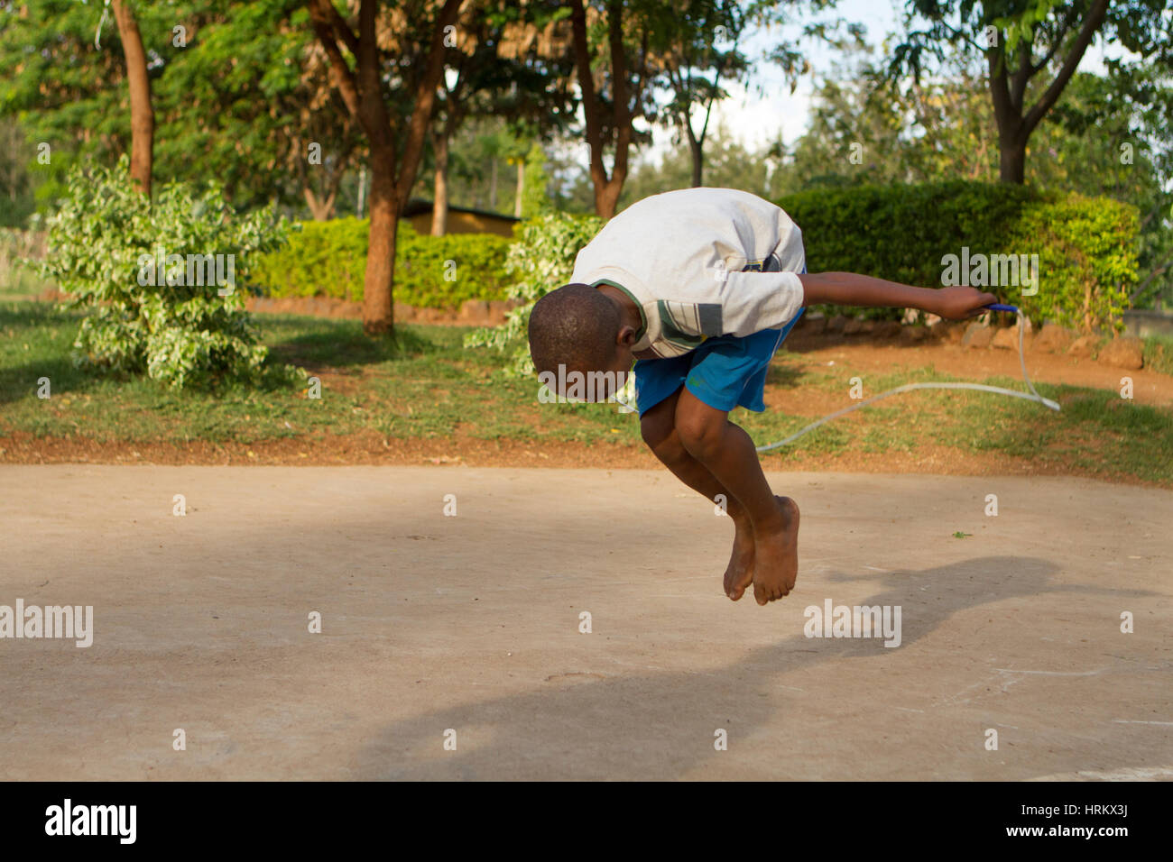 Jumping rope child in Africa, rope skipping African boy Stock Photo