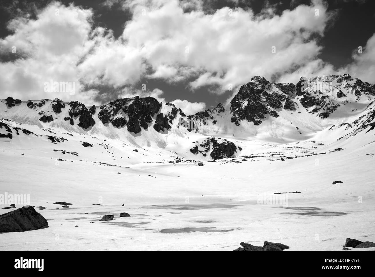 Black and white view on frozen mountain lake covered with snow at sun day. Turkey, Kachkar Mountains, highest part of Pontic Mountains. Stock Photo