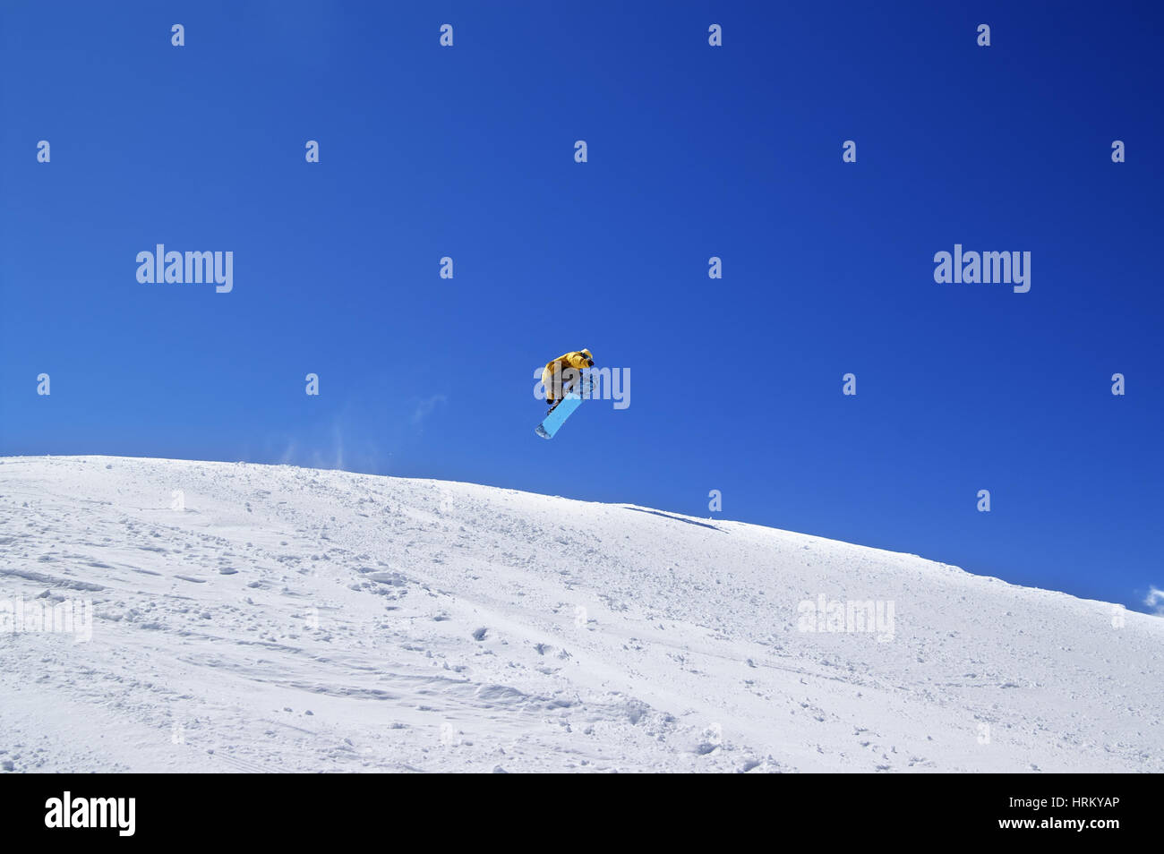 Snowboarder jump in terrain park at ski resort on sun day. Caucasus Mountains, region Dombay. Stock Photo