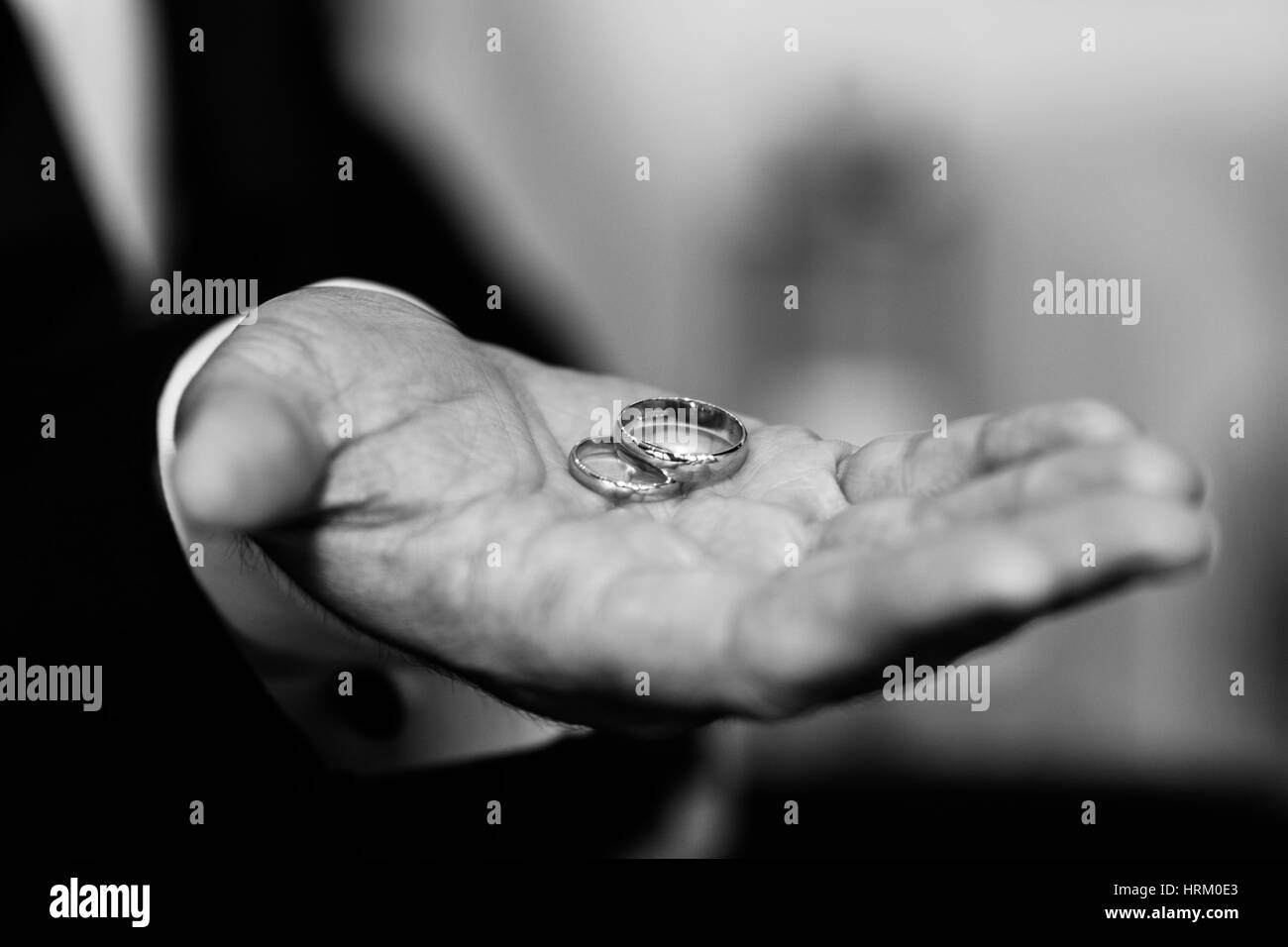 Wedding rings held by the groom Stock Photo