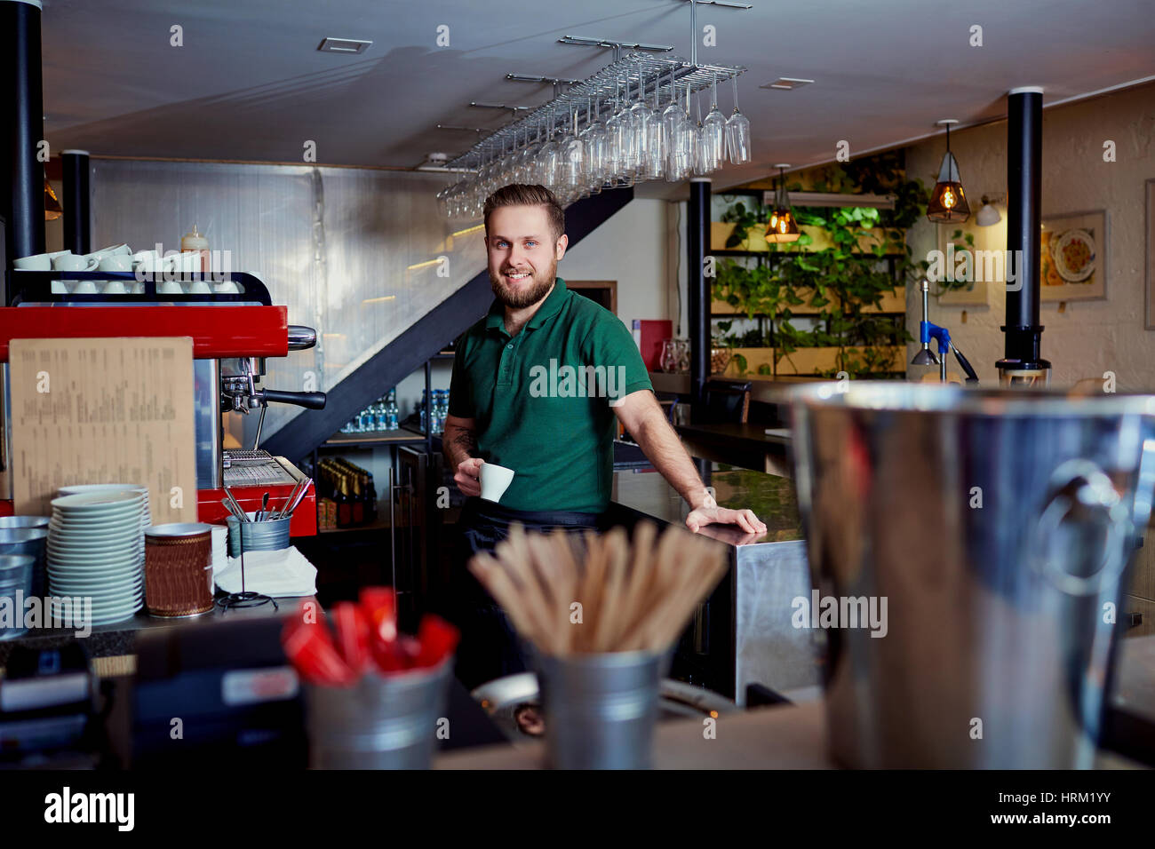 Bartender barista with coffee in hand behind the bar at the brea Stock Photo