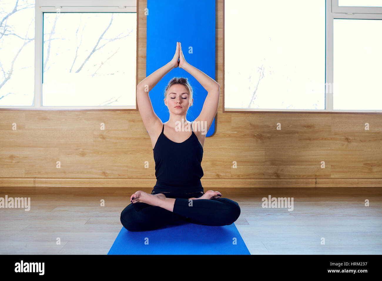 Girl sitting in a yoga pose gym. Relaxation meditation health Stock Photo