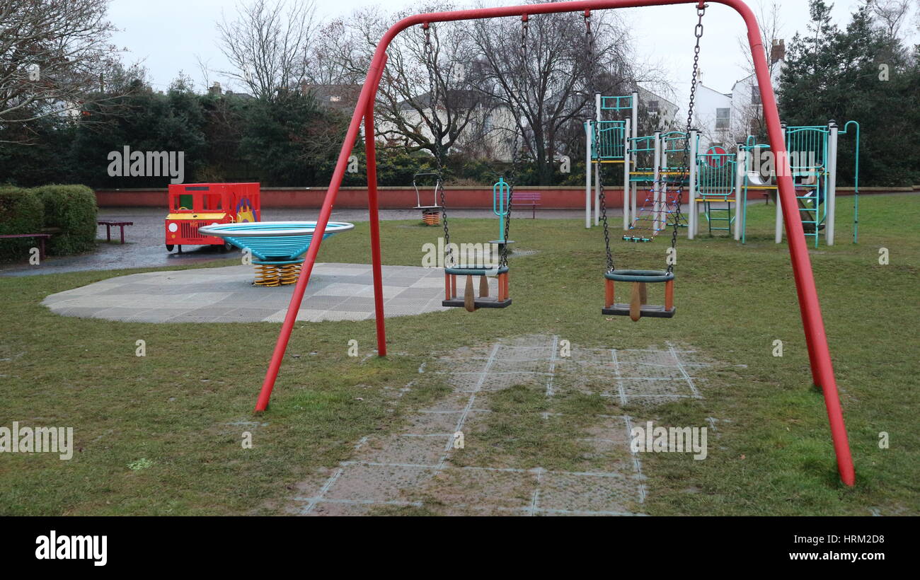Children's playground with a swing in a park, Cheltenham, UK Stock