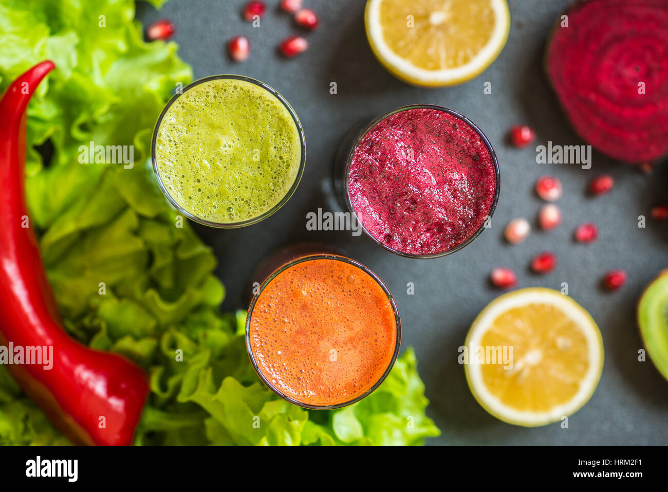 three glasses of different fresh juice. Beet, carrot and kiwi juices on