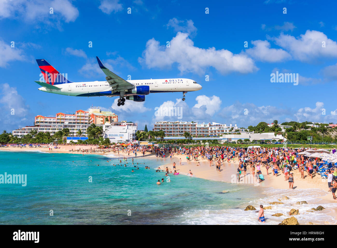 PHILIPSBURG, SINT MAARTEN - DECEMBER 28, 2016: A commercial jet approaches Princess Juliana airport above onlooking spectators. The short runway gives Stock Photo