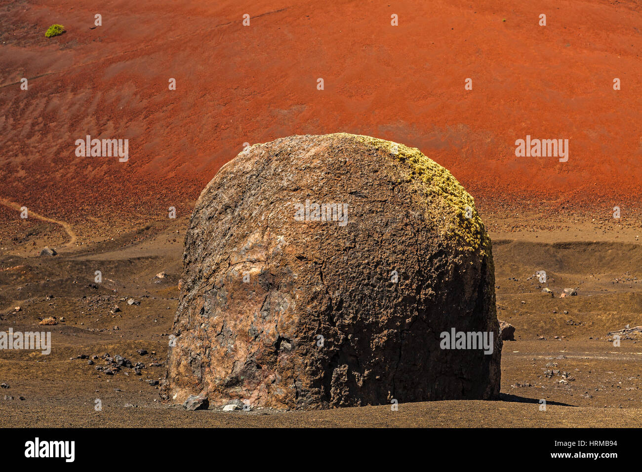 Volcanic bomb in front of volcano Montana Colorada in Lanzarote, Canary Islands, Spain. Stock Photo
