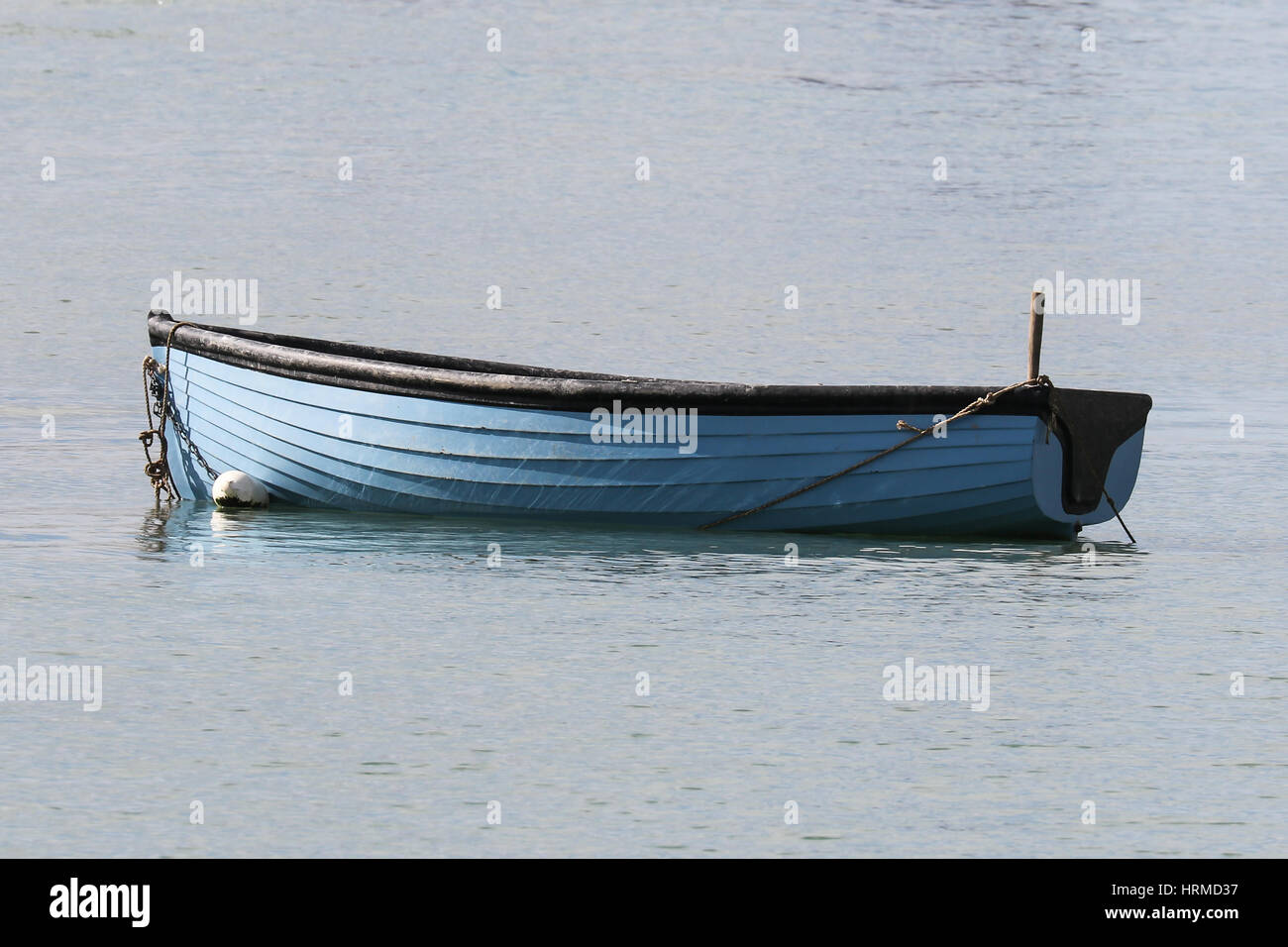 A blue rowing boat sat in the bay of Portsmouth Harbour Stock Photo