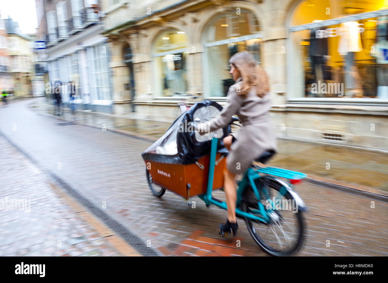 Cargo bike, a woman and children ride a cargo through central Cambridge Stock Photo