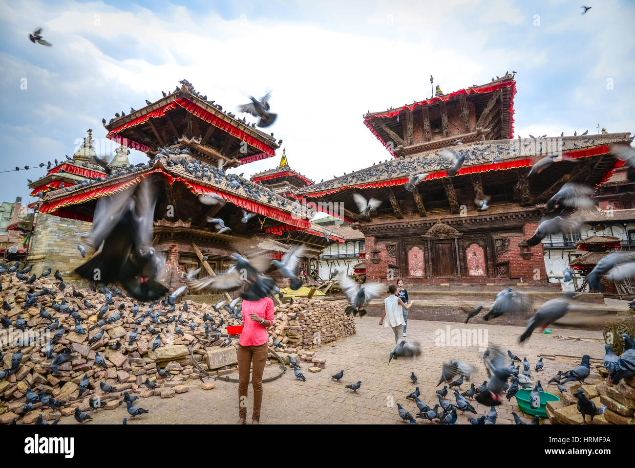 Nepali young girls feed doves in the yard of the historic Jagannath ...