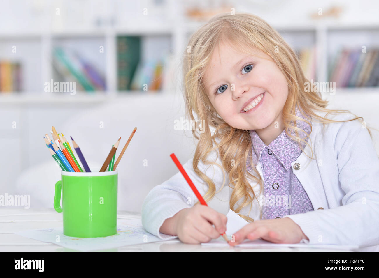 Portrait of a cute little girl drawing with pencils Stock Photo - Alamy