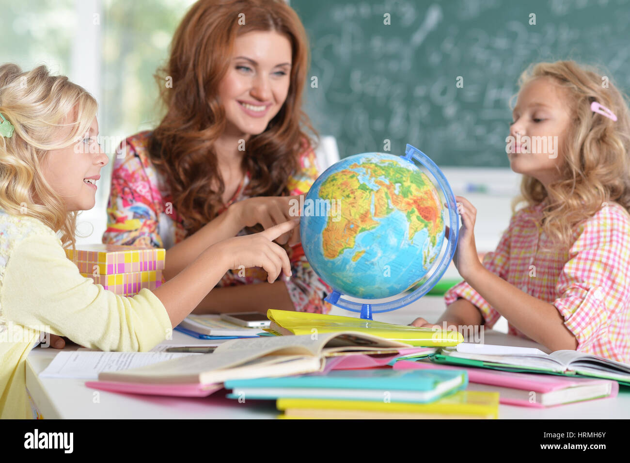 Portrait of teacher with two girls at lesson Stock Photo - Alamy