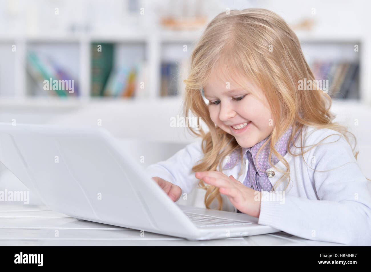 Portrait of a cute happy little girl using laptop Stock Photo - Alamy