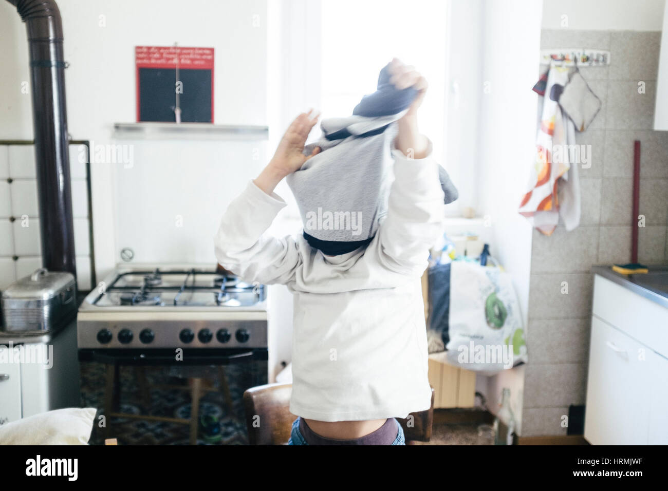 child takes off sweater at home Stock Photo Alamy