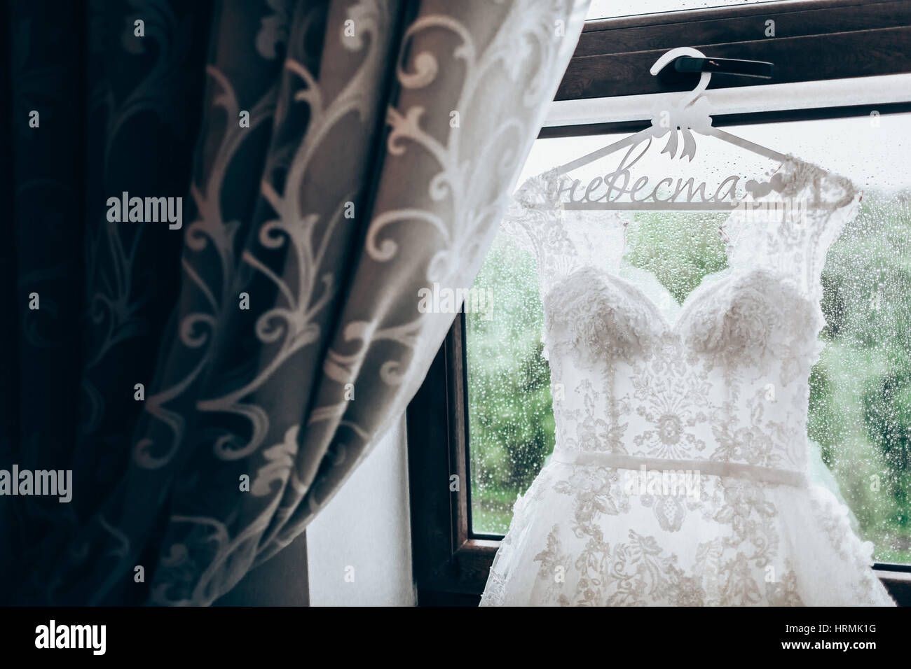 Wedding Dress Hanging On A Window With Curtains Close Up Stock