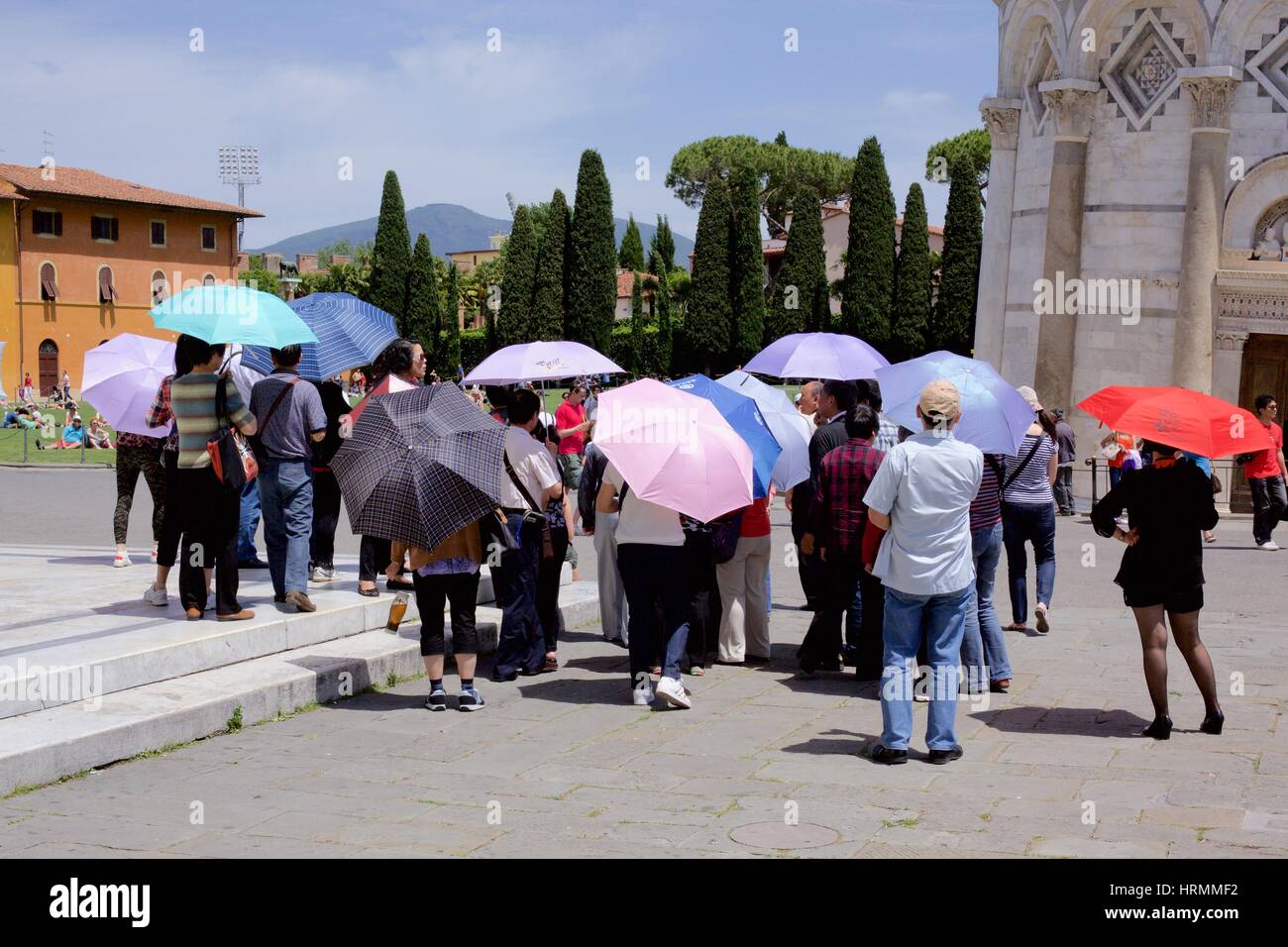 tourists at Piazza dei Miracle, Pisa, Italy with colourful open umbrellas in the sunshine Stock Photo