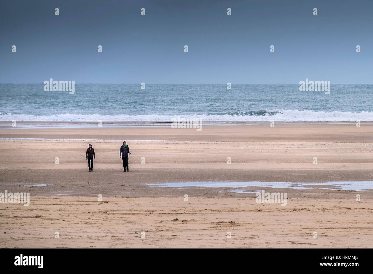 Two people distance walking Crantock Beach Newquay Cornwall. Stock Photo