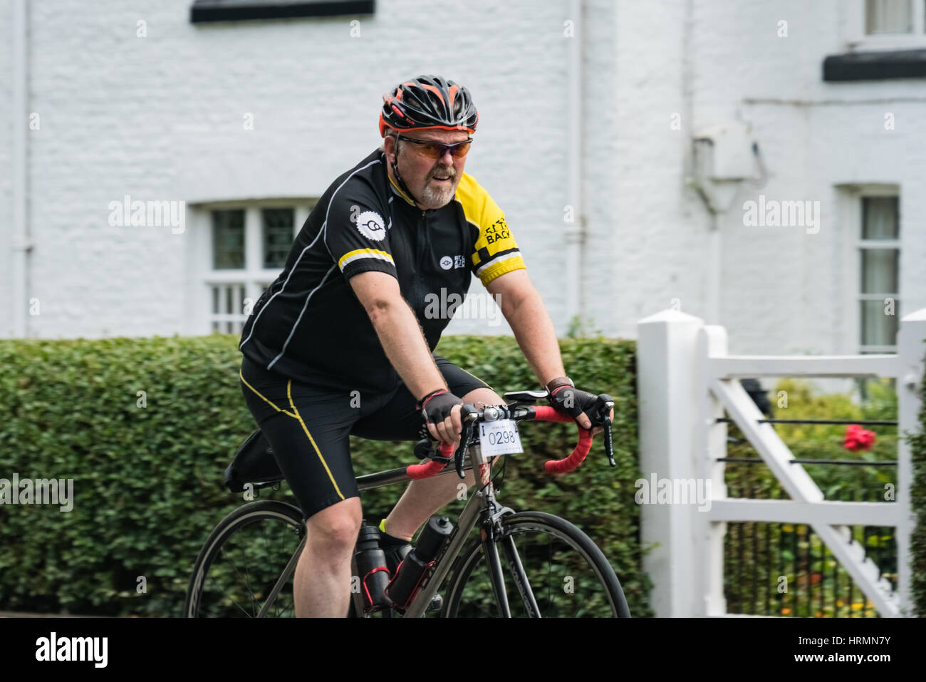Cyclist in the Rise Above sportive riding through Pulford near Chester Stock Photo