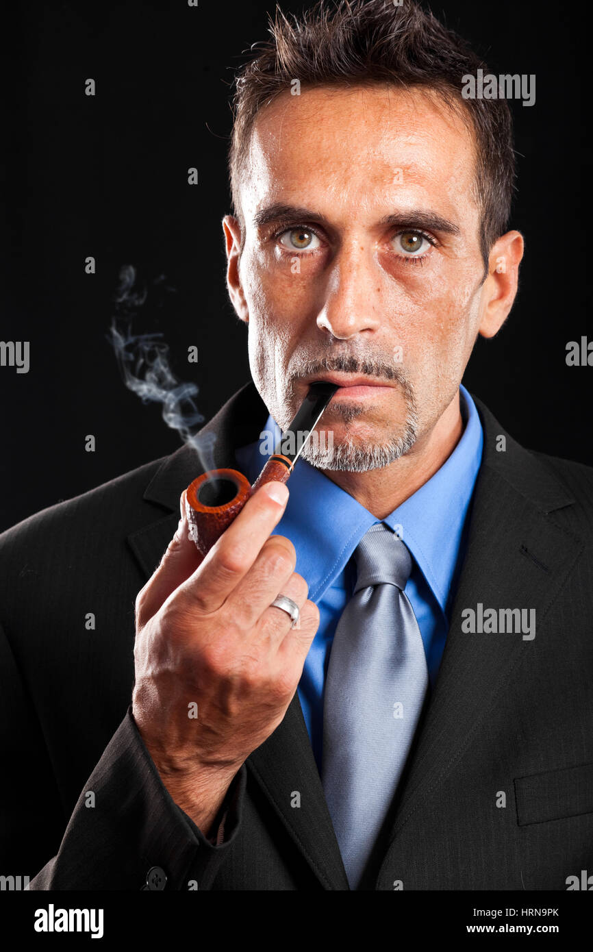 Classy man smoking a pipe against a dark background Stock Photo Alamy