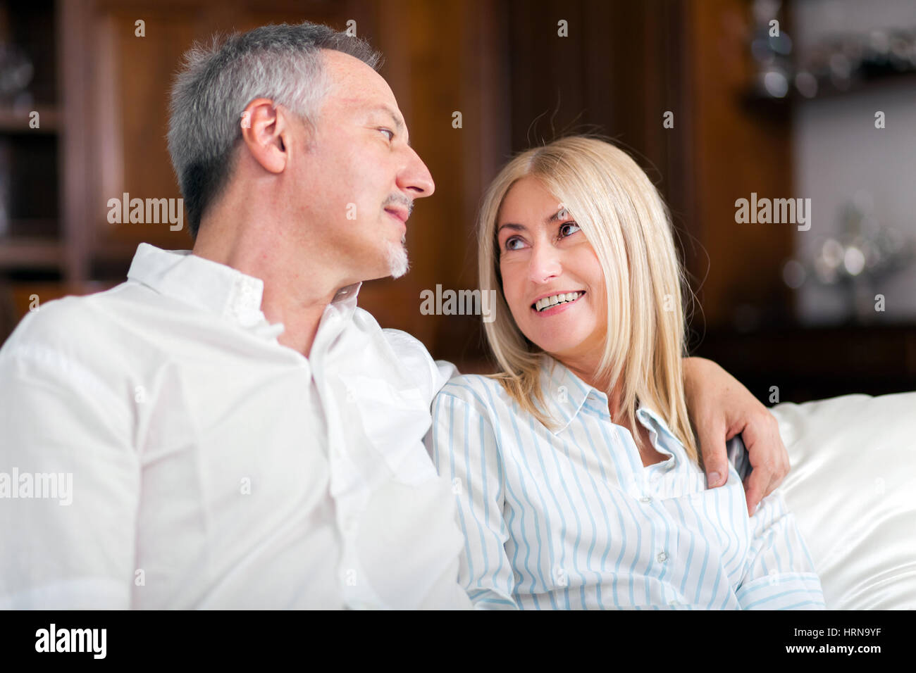 Senior Couple Relaxing On Sofa At Home Stock Photo - Alamy
