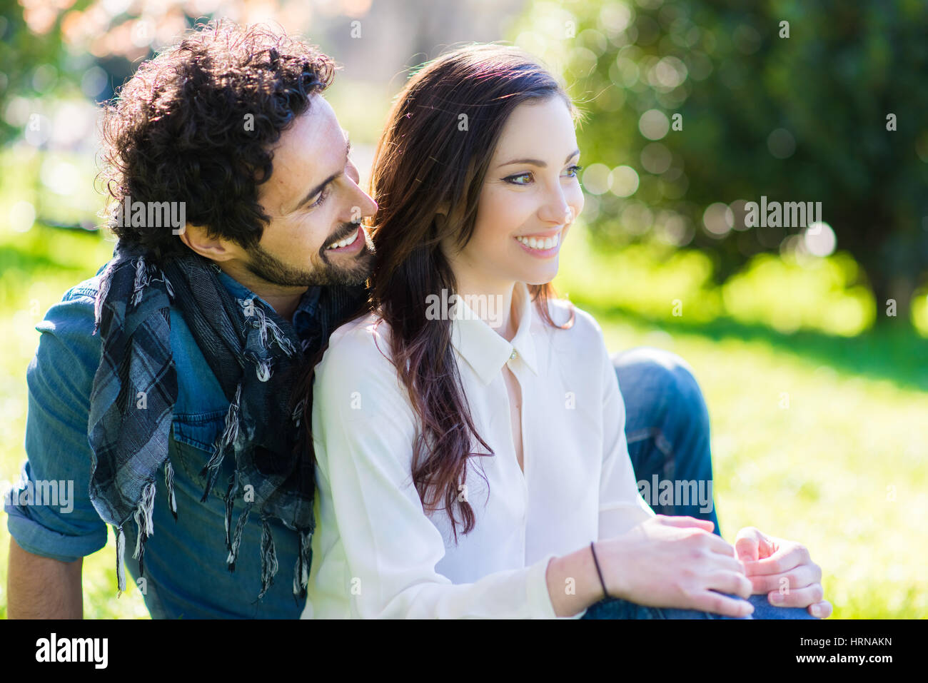 Young couple relaxing on the grass in the park Stock Photo - Alamy