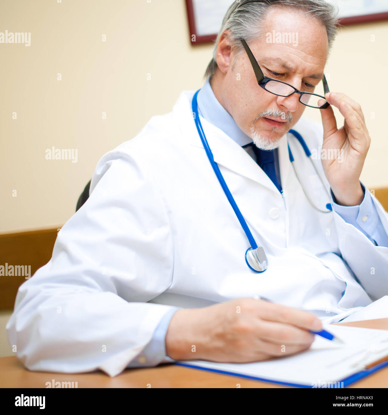 Handsome doctor writing in hi-res stock photography and images - Alamy