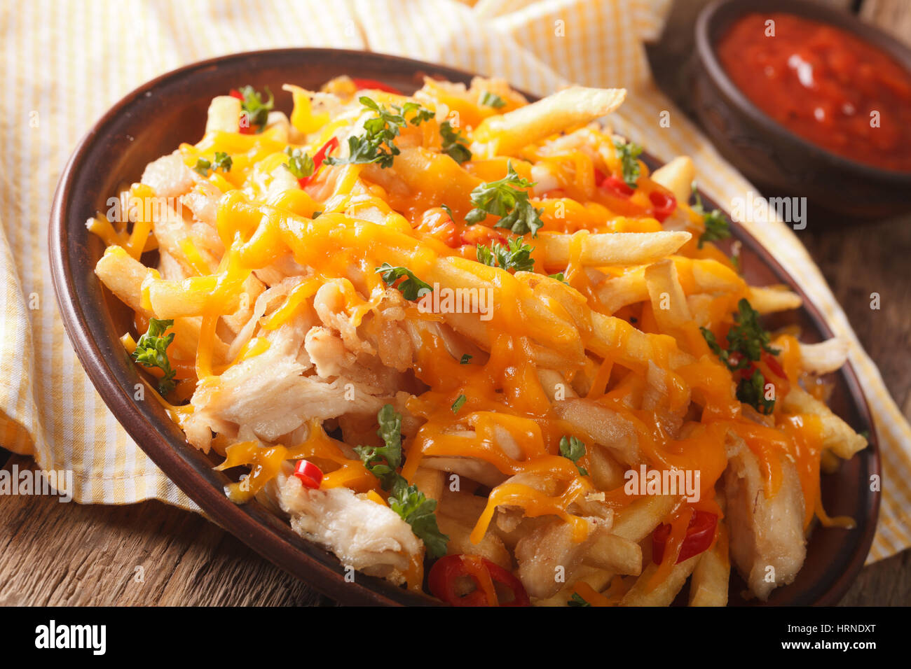 french fries with cheddar cheese, chili and chicken close-up on a plate. horizontal Stock Photo