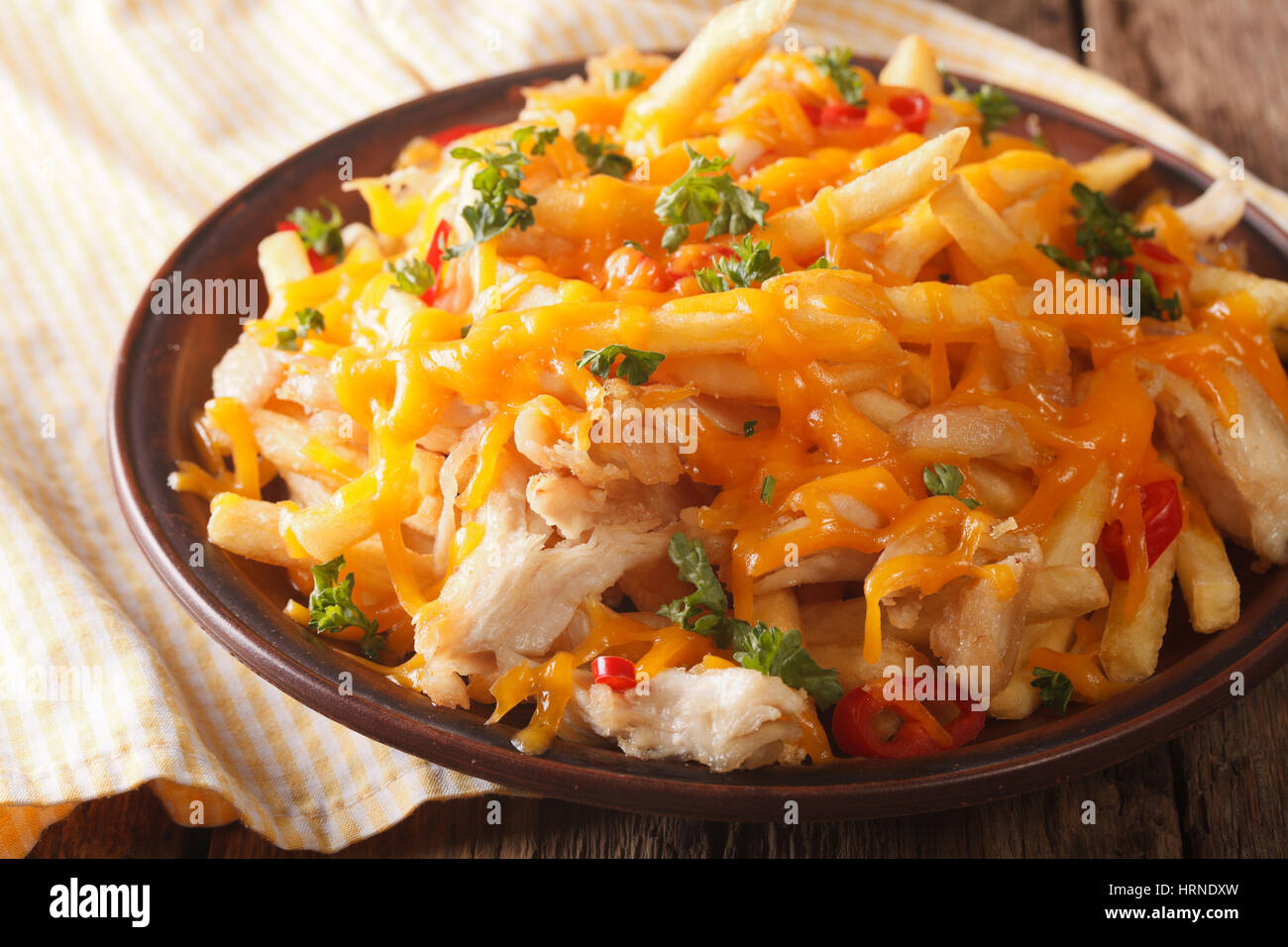 french fries with cheddar cheese and chicken meat close-up on a plate. horizontal Stock Photo