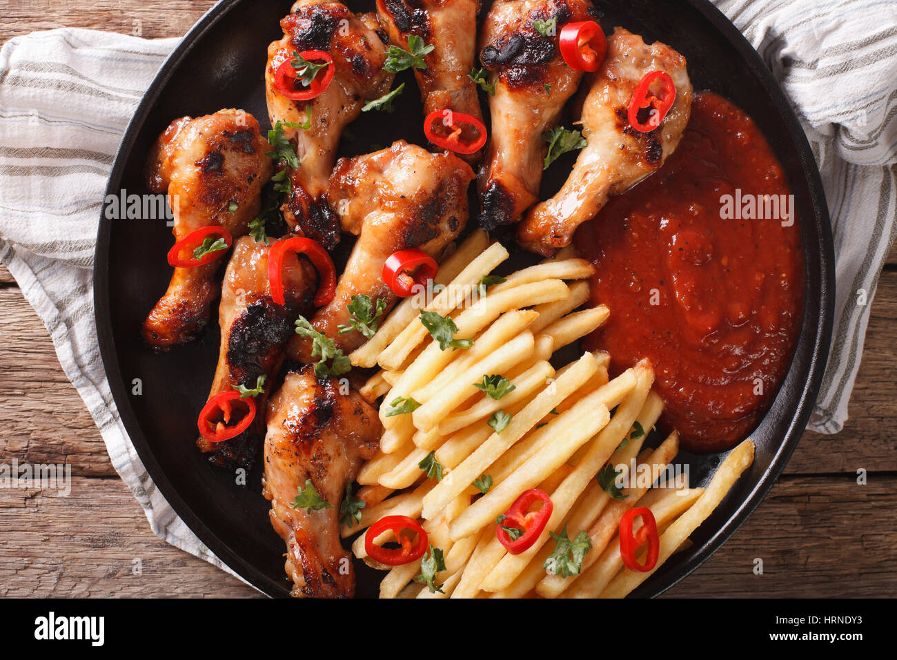 Grilled chicken wings with french fries and ketchup on the table close-up. horizontal view from above Stock Photo
