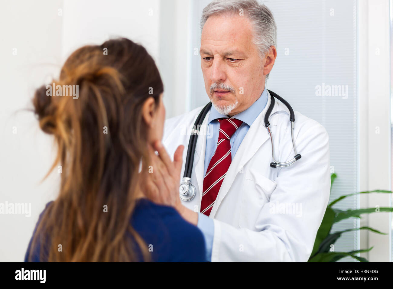 Doctor checking the lymph nodes size of a patient Stock Photo