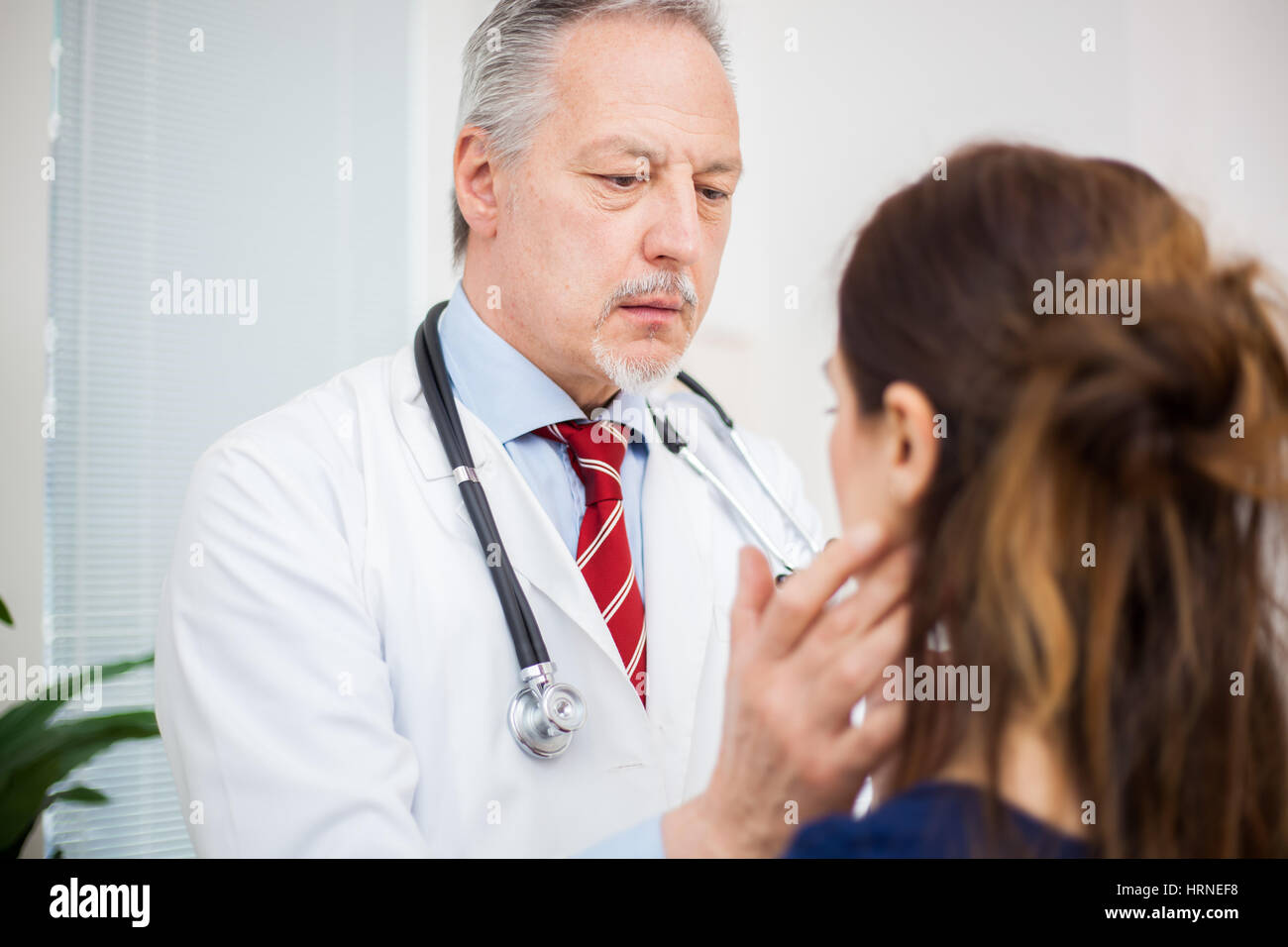 Doctor checking the lymph nodes size of his patient Stock Photo