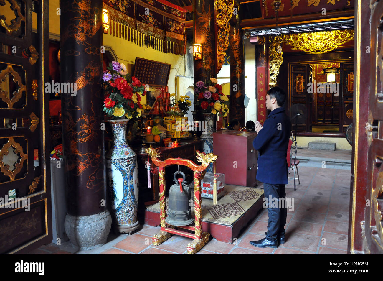 HANOI, VIETNAM - FEBRUARY 19, 2013: Buddhist worshippers praying in the interior of Bac Ma temple in Hanoi Vietnam Stock Photo