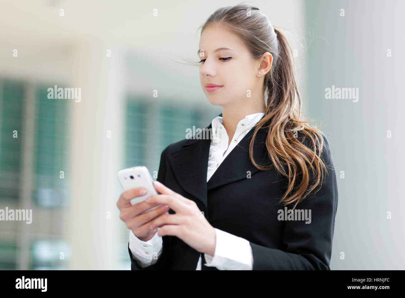 Businesswoman sending a sms outdoor Stock Photo