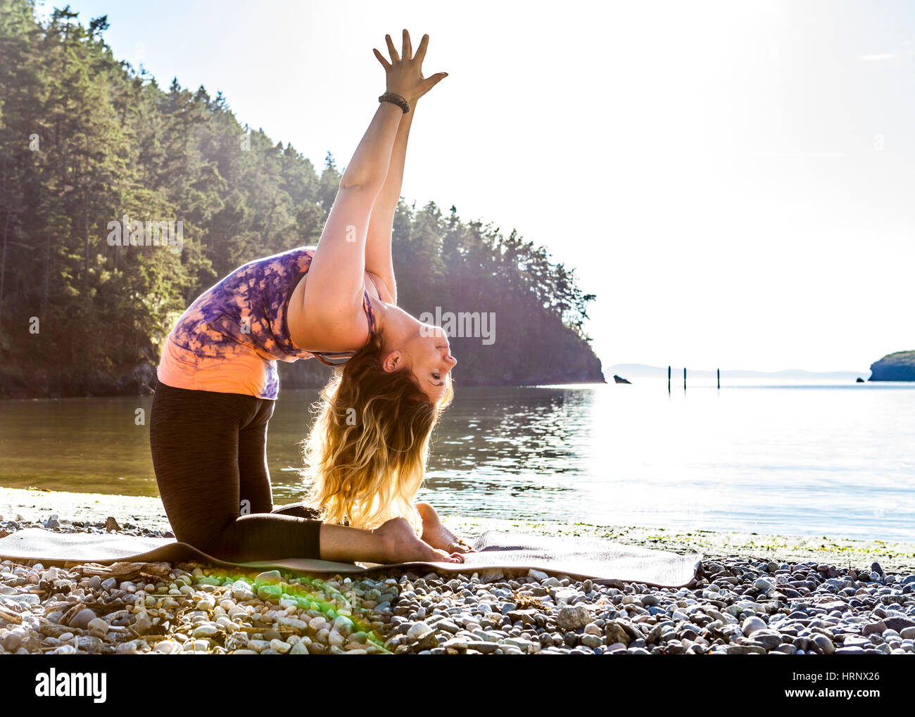 A woman practicing yoga in a beautiful outdoor setting. Stock Photo