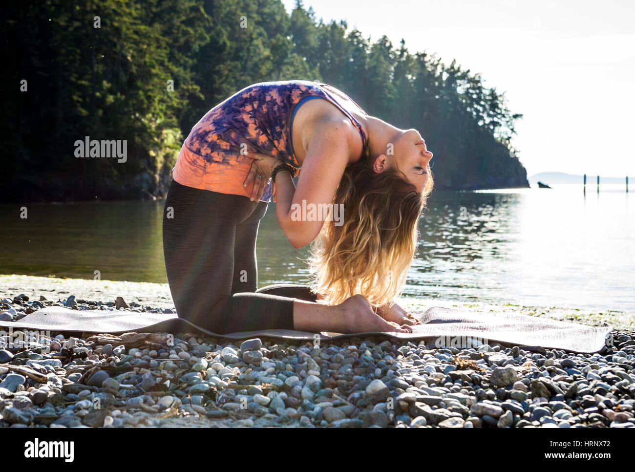 A woman practicing yoga in a beautiful outdoor setting. Stock Photo