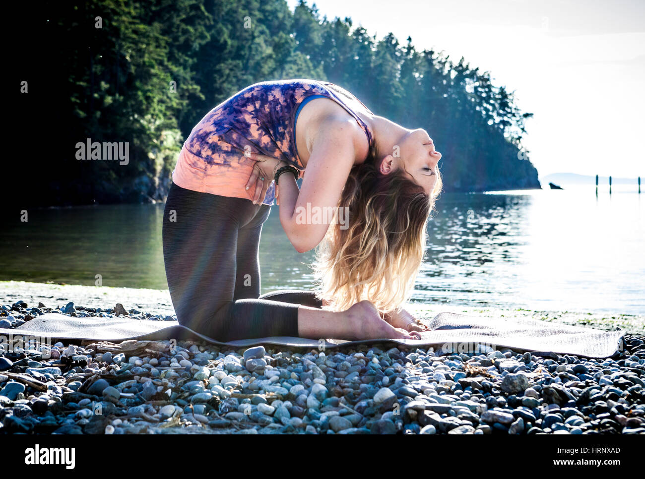 A woman practicing yoga in a beautiful outdoor setting. Stock Photo