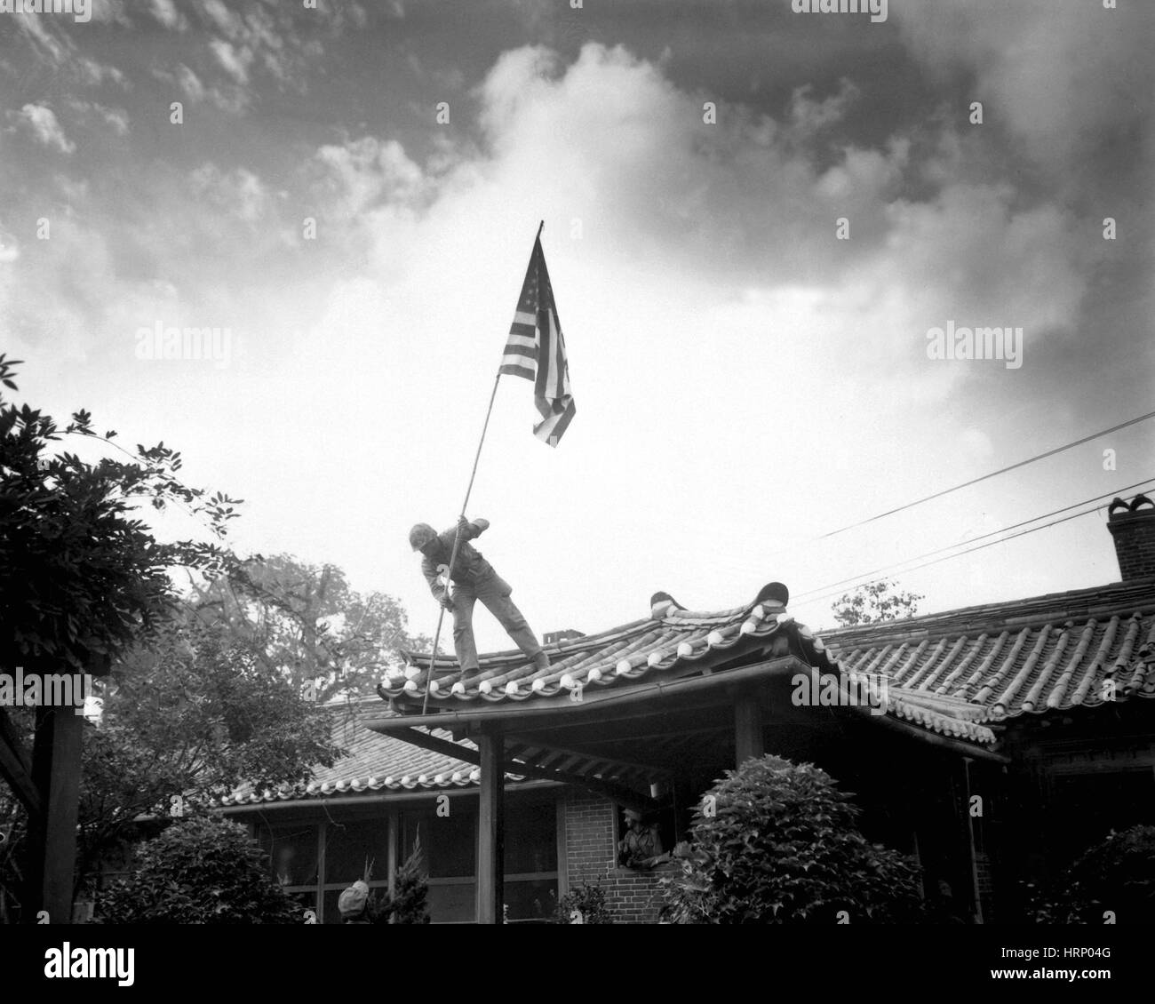 Korean War, Soldier Raises U.S. Flag, 1950 Stock Photo