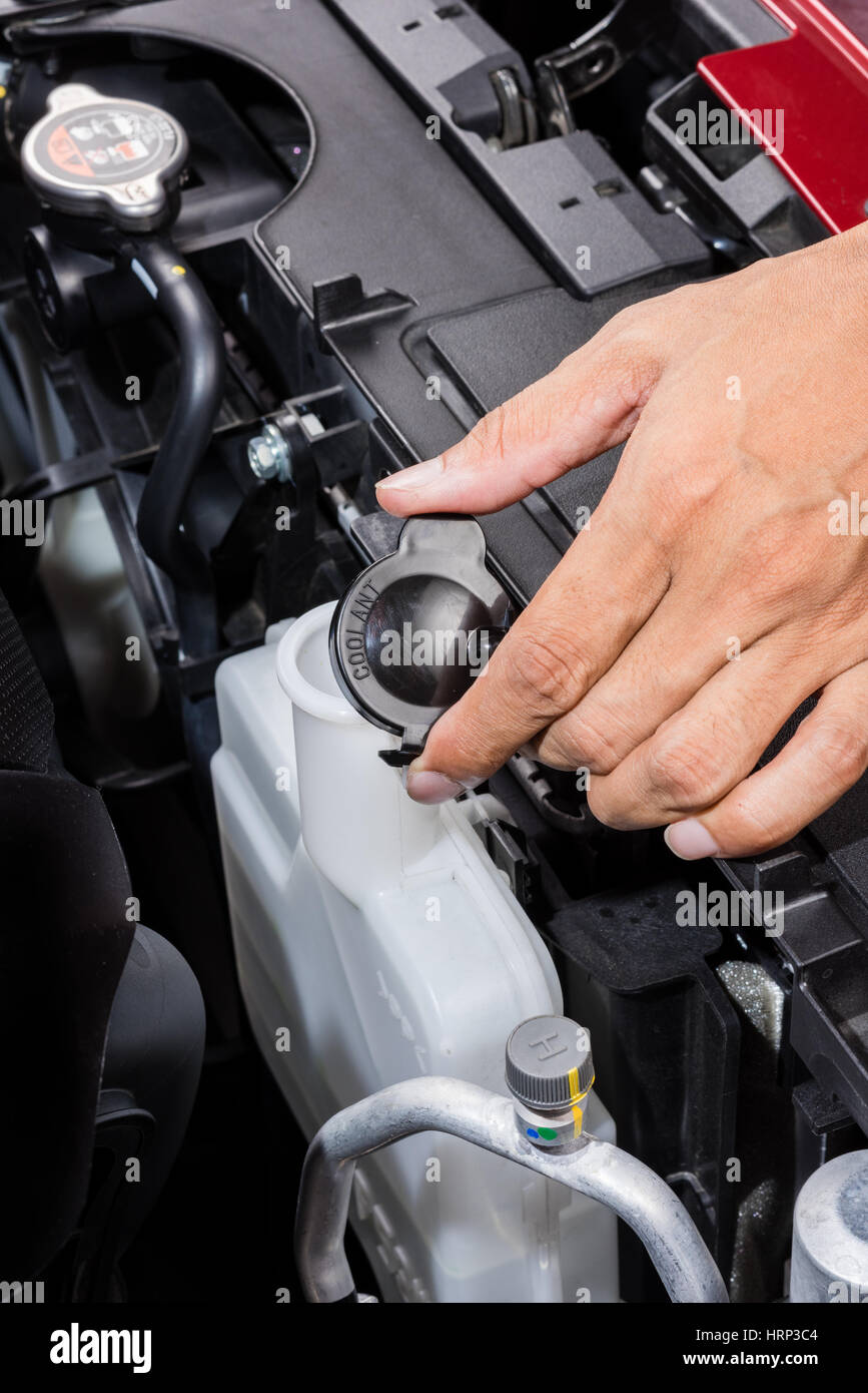 opening coolant container in engine room, car maintenance concept Stock